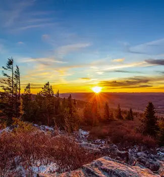 Scenic overview photo taken from the highest point in West Virginia State, Spruce Knob at sunset with trees and snow covering the floor.