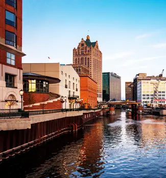 Downtown Milwaukee buildings lining the sides of a water canal.