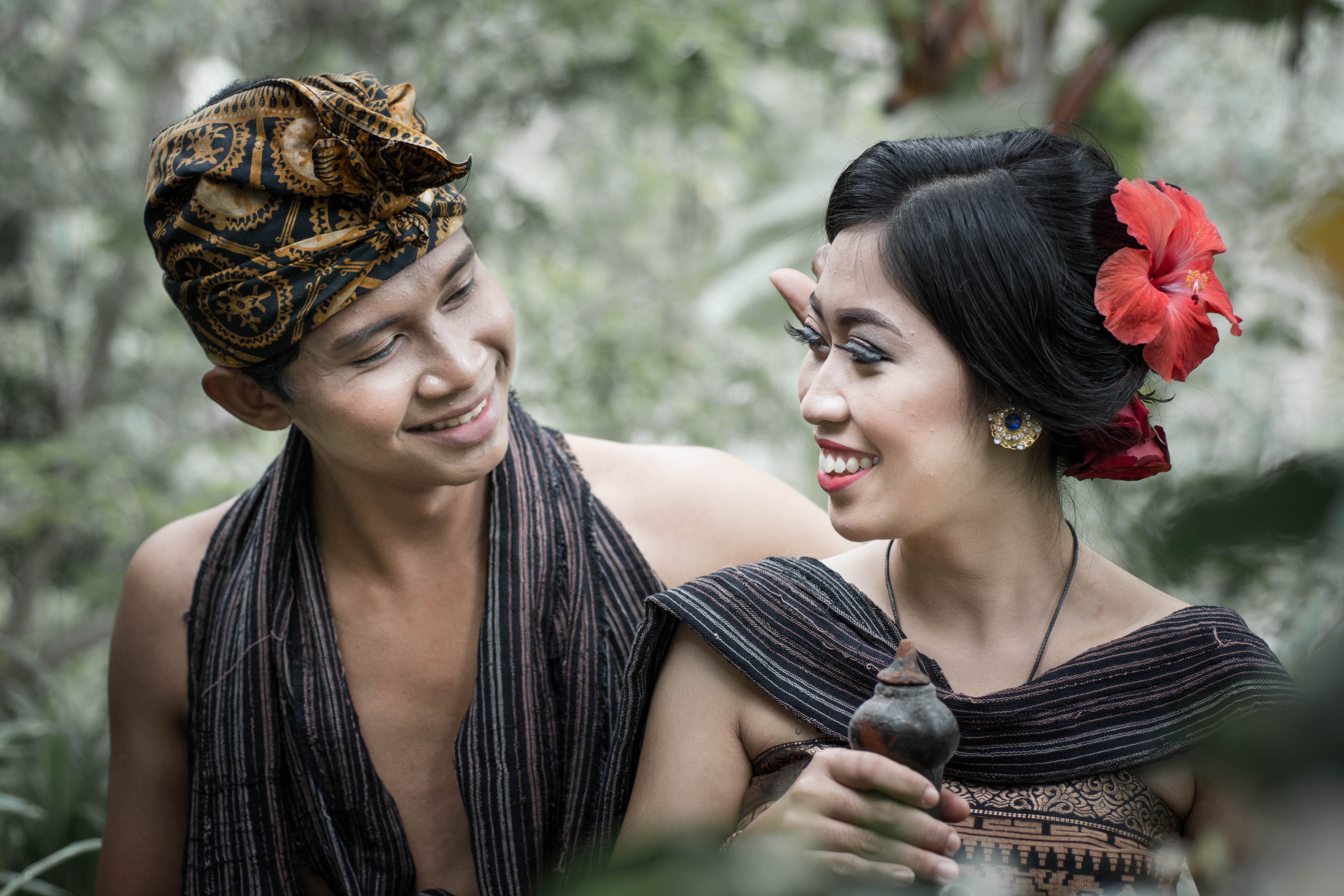 Pantai berpasir putih dengan ombak lembut dan langit senja berwarna oranye kemerahan