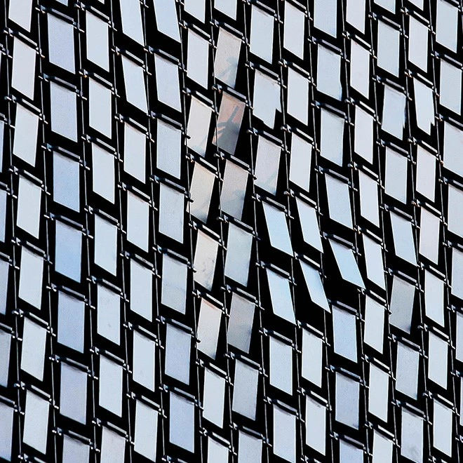 Reflective Cascading Keys arranged vertically creating a kinetic facade system.