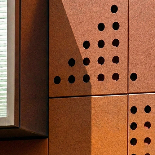 Reflective metacorten arranged vertically creating a kinetic facade system.