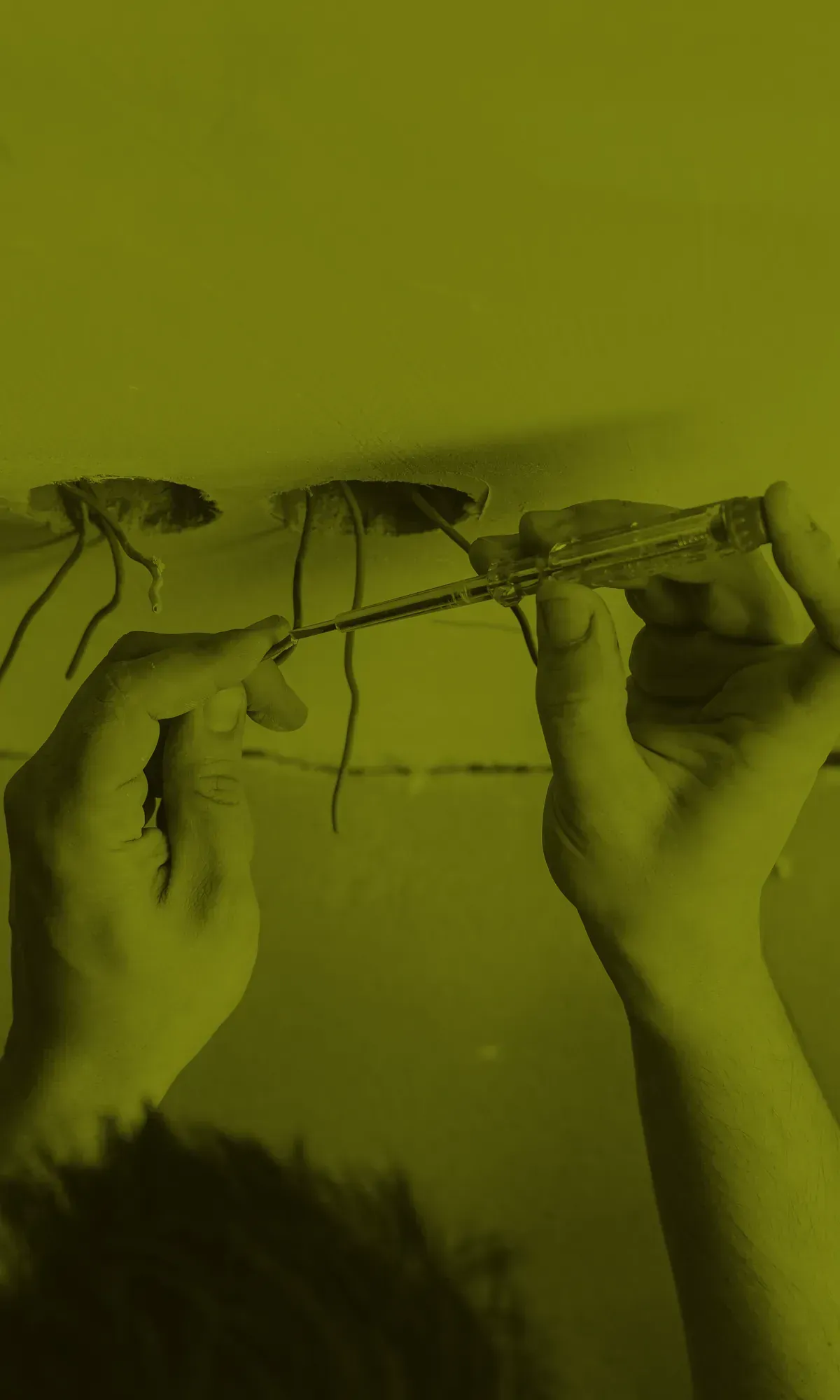 Electrician working wiring a ceiling light fitting