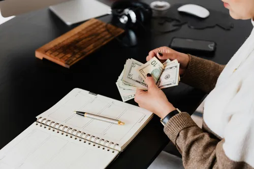 a woman with dollars in her hands counting money