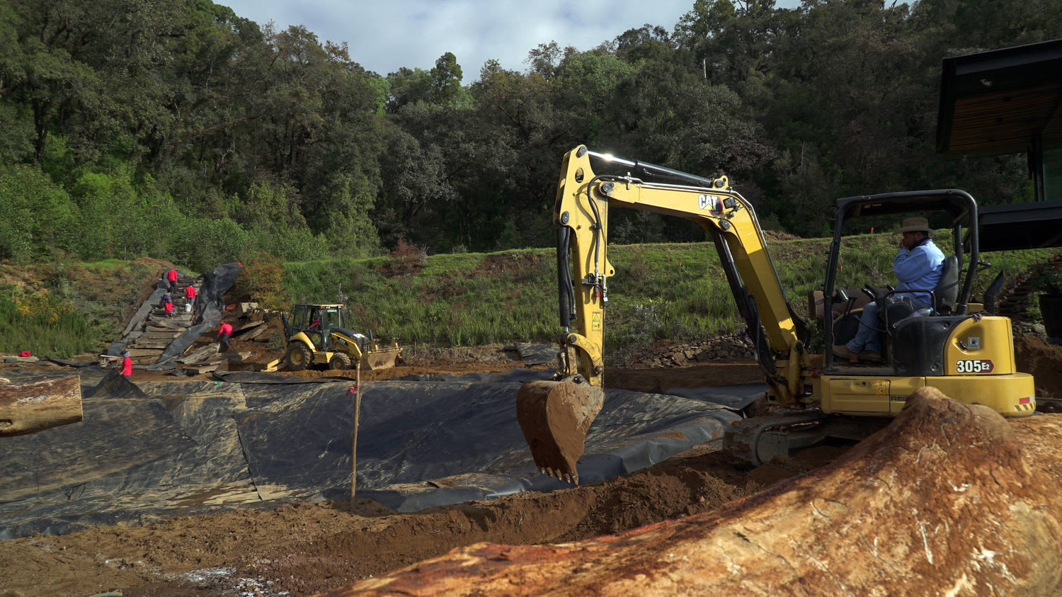 Miniexcavadora perfilando el vaso del estanque
