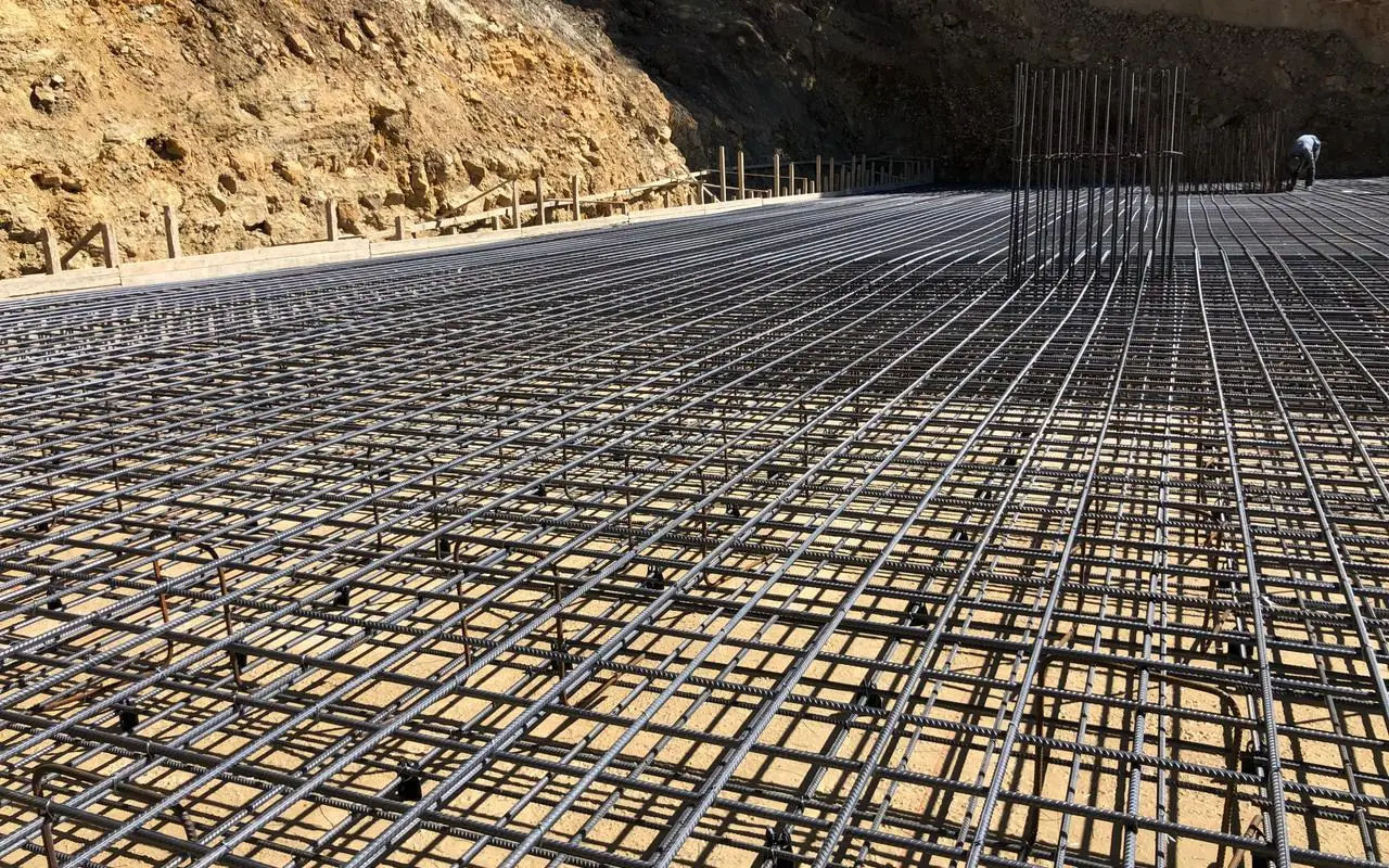 Reinforcement mesh laid out across a raft foundation before the pour