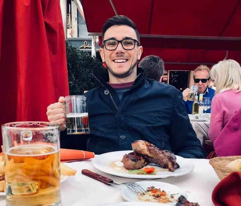 man with eyeglasses in front of the table with meal