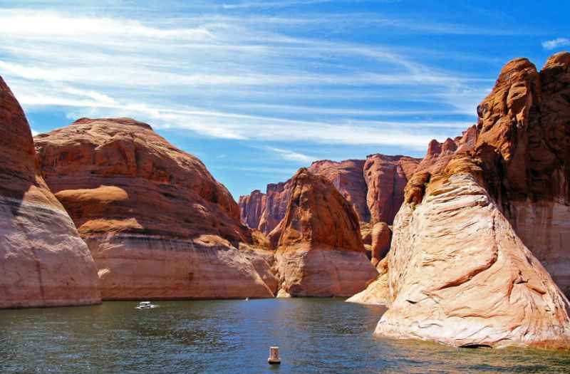 a boat is in the water near some rocks