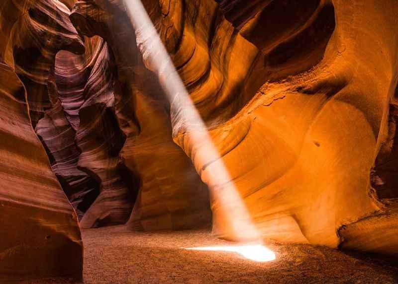 a light shines through the slot canyon in anto canyon