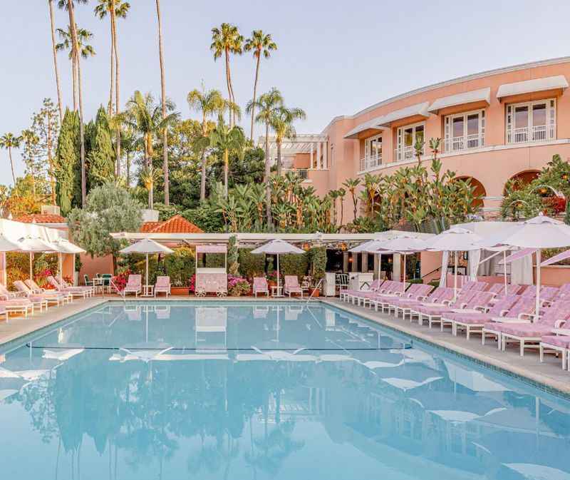 the pool at the hotel with pink sunlounger