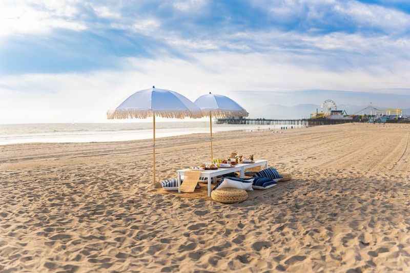 a beach with a picnic table and umbrellas on it