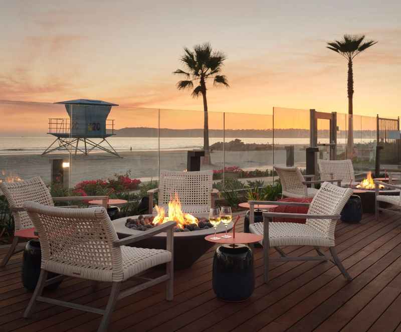 a fire pit on a deck with chairs and tables