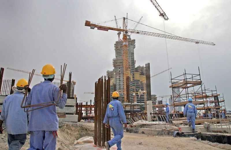 construction workers walk past the construction site