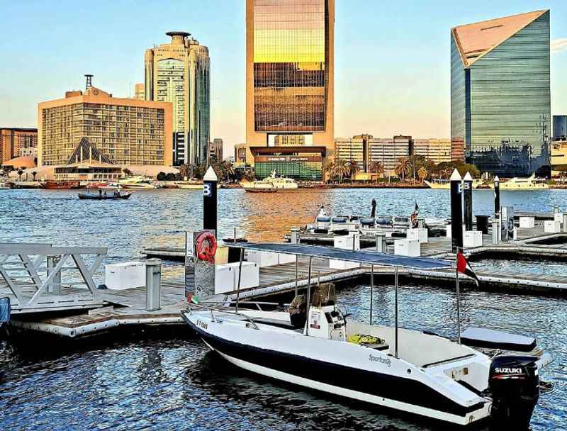 a boat docked in the water near a city