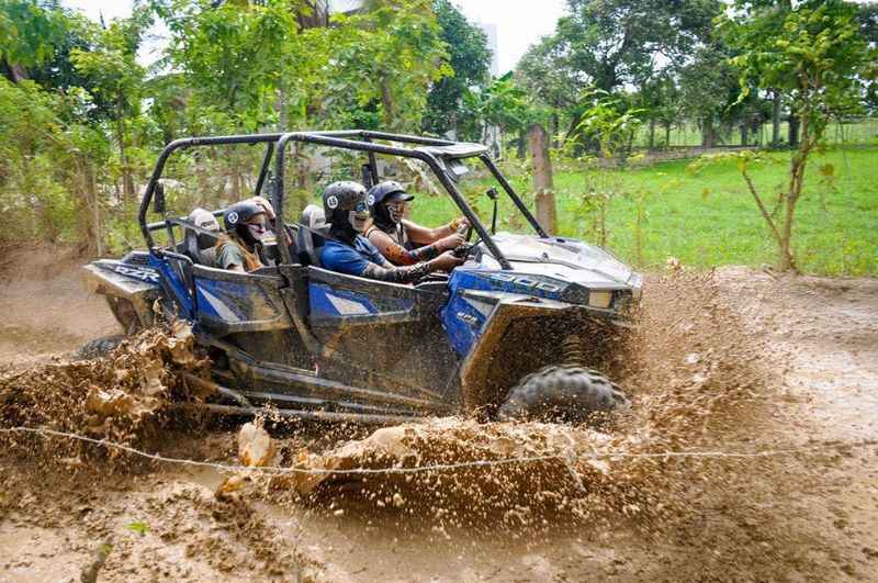 a man driving an ATV car with passengers