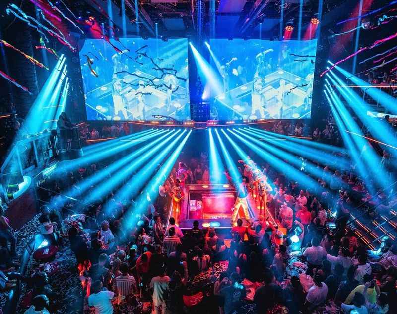 people at a nightclub with blue and purple lights