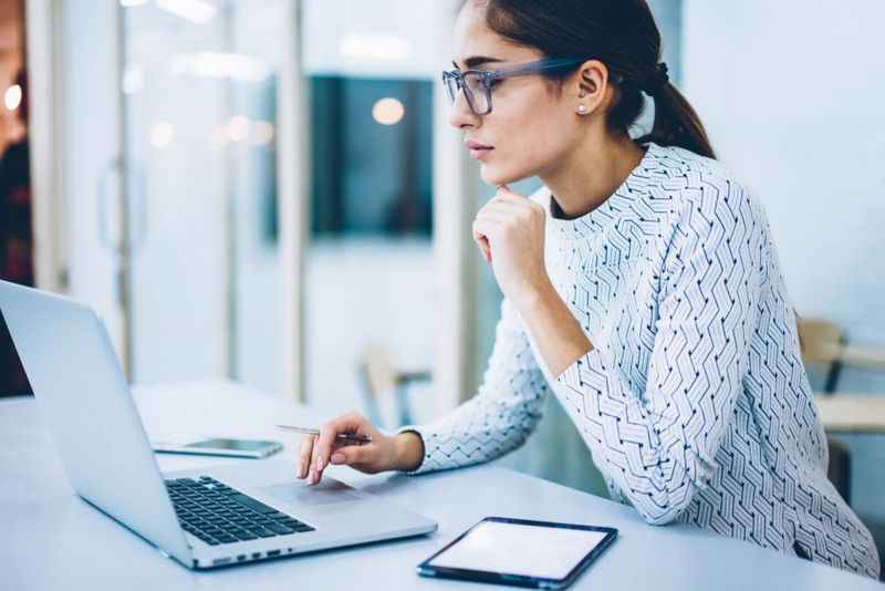 a woman with eyeglasses in front of her laptop