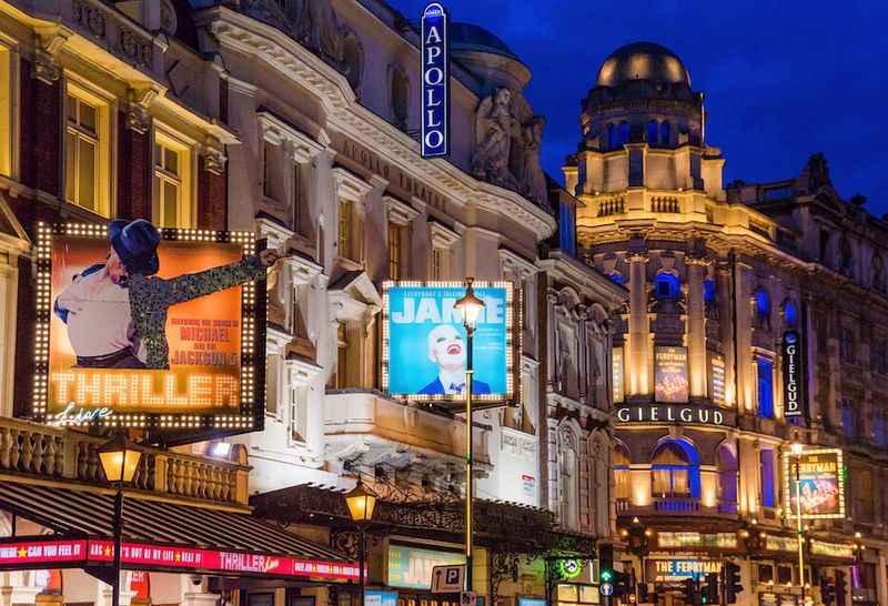 Street view of London West End with bright lights and theatre signs