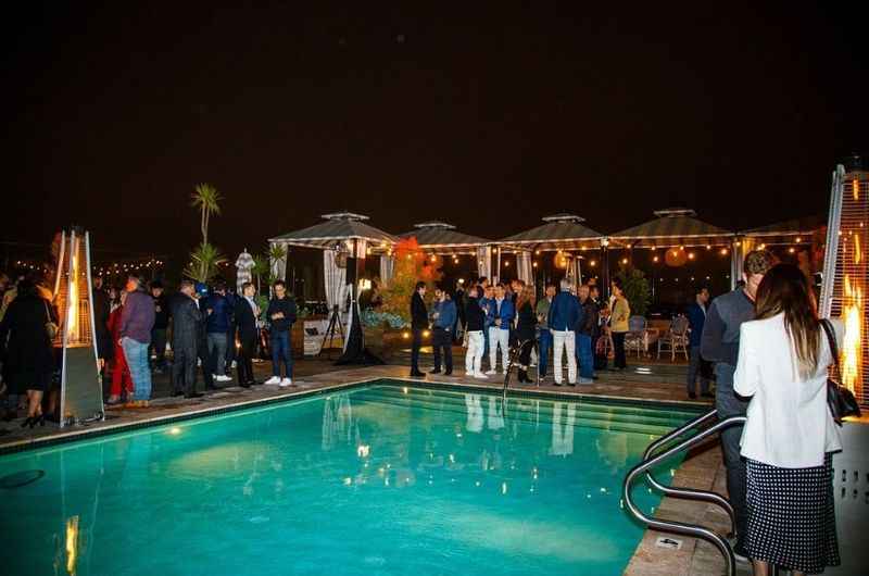 a group of people standing around a pool