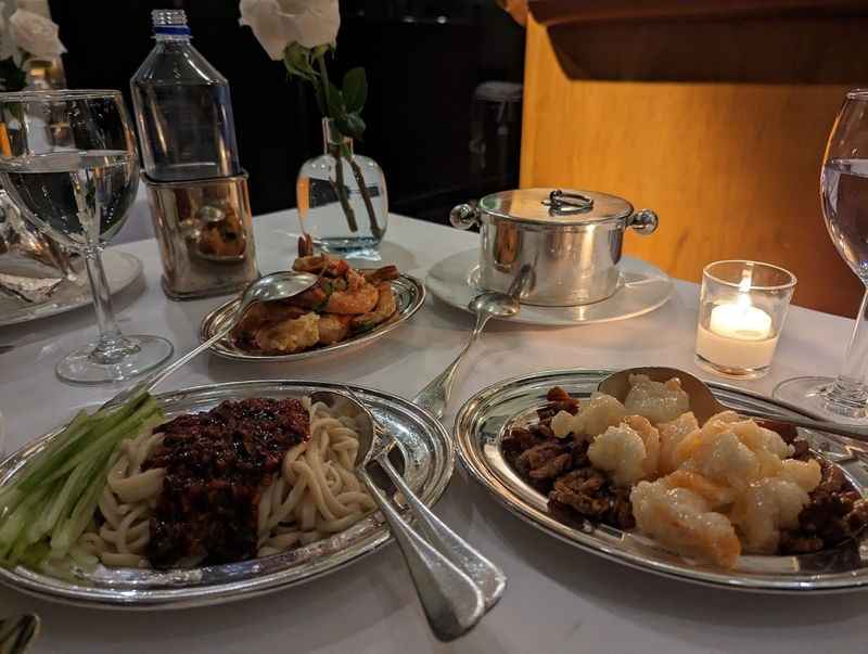 a table with plates of food and glasses of wine