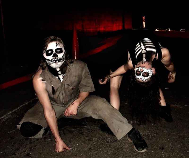 two men sitting with skeleton mask on