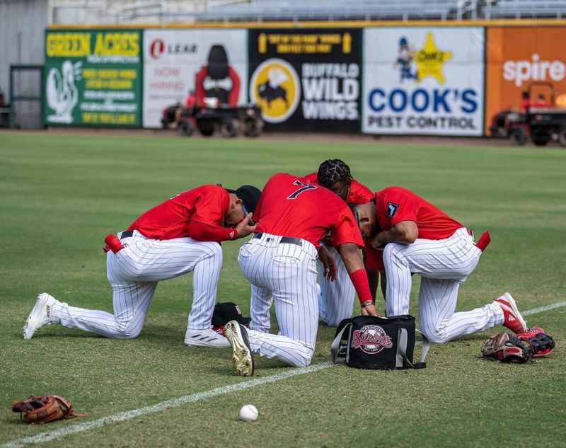 a group of baseball players kneeling on the field