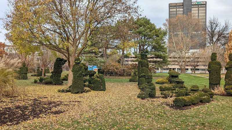 a park with trees and bushes in the fore