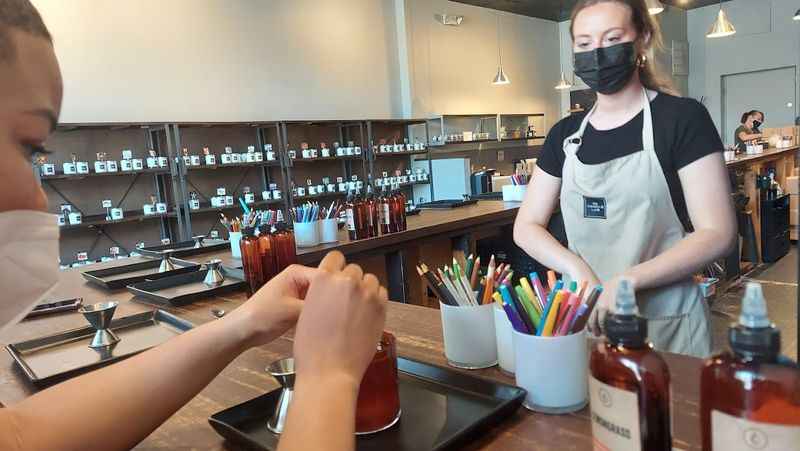 a woman in a mask is making a drink