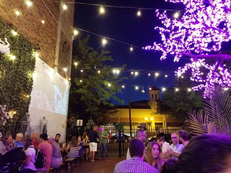 people sitting at tables under string lights