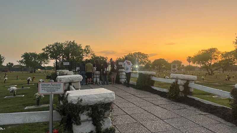 a cemetery with graves and people walking around it