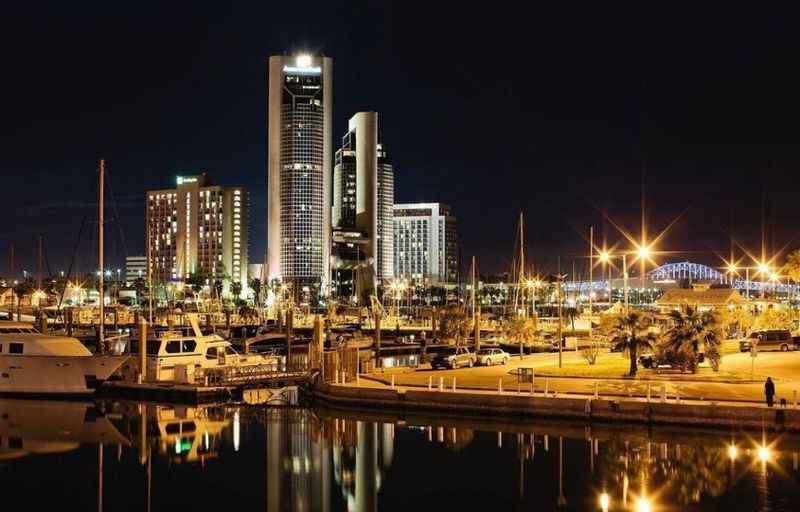 boats docked at night with golden colored lights