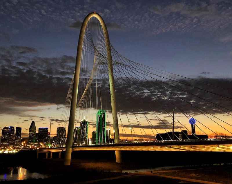 bridge at night with the city skyline in the background