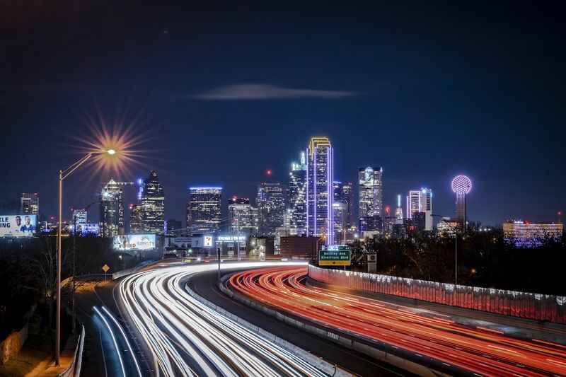 a city skyline at night with light trails