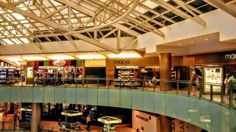 a large atrium with a glass ceiling and a glass railing