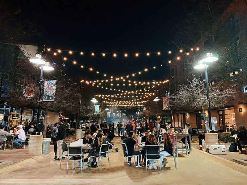 a group of people sitting at tables in a city