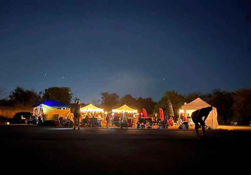 a group of people standing around tents at night