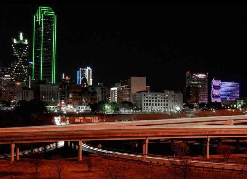 a city skyline at night with a freeway