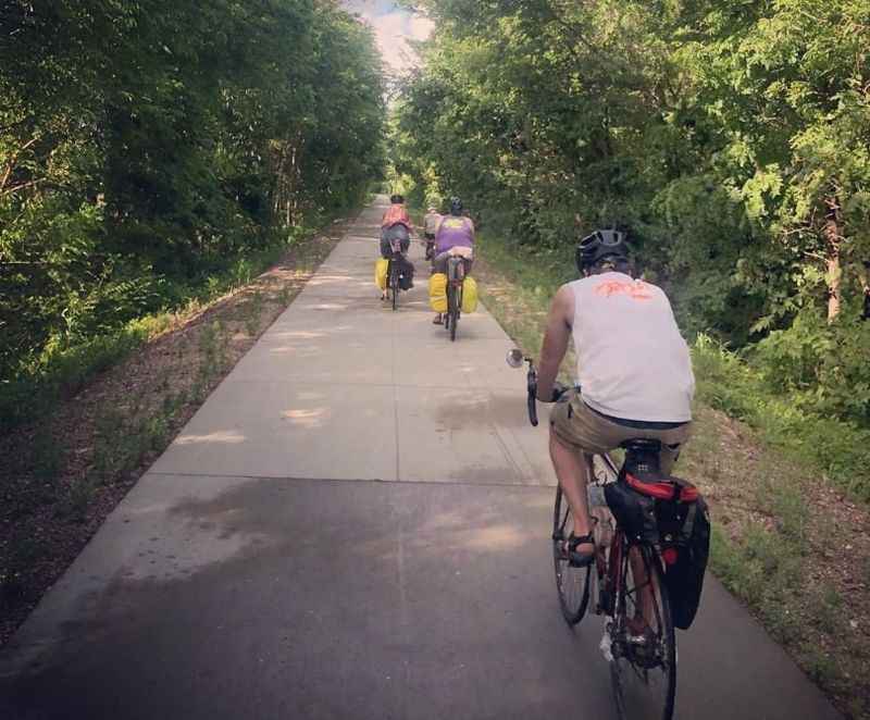 a group of people riding bikes down a path