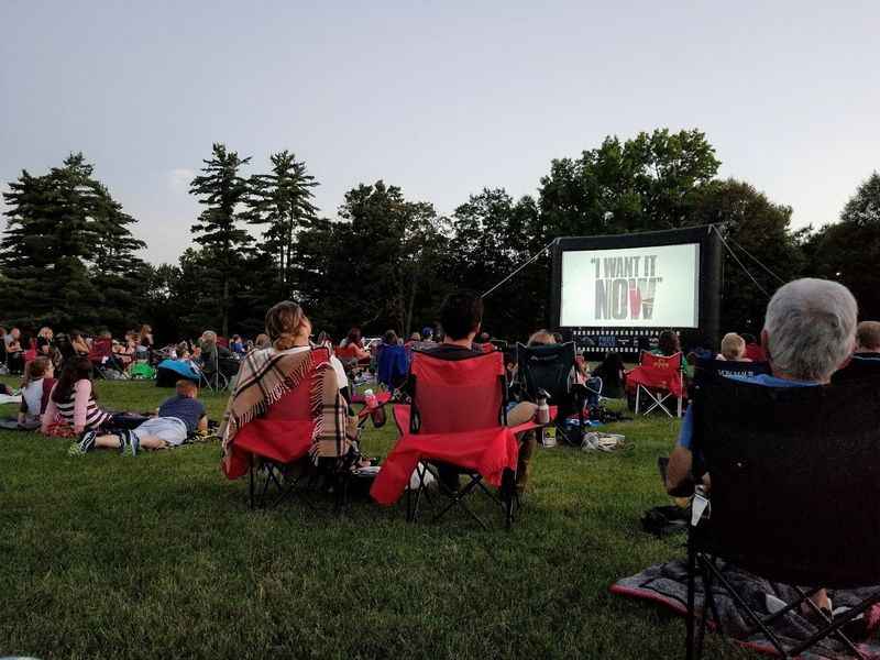 people sitting in lawn chairs watching a movie