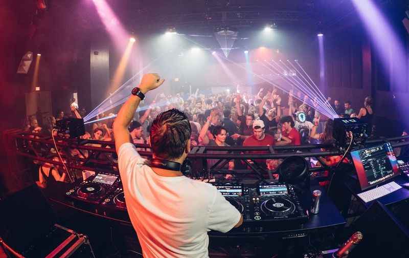 a dj at a nightclub with a crowd