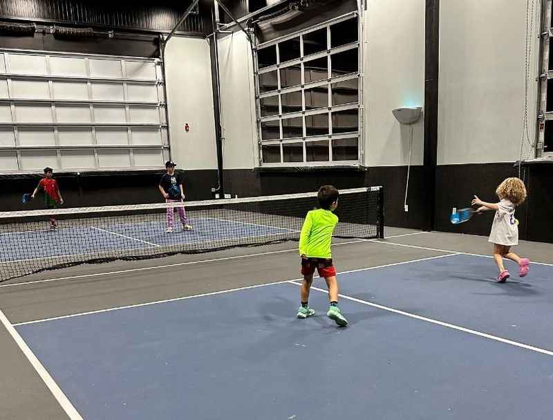 two young boys playing tennis on a court