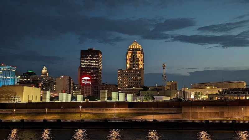 a city skyline at night with a river in front