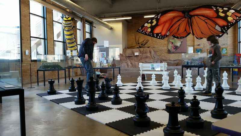 a man standing on top of a chess board