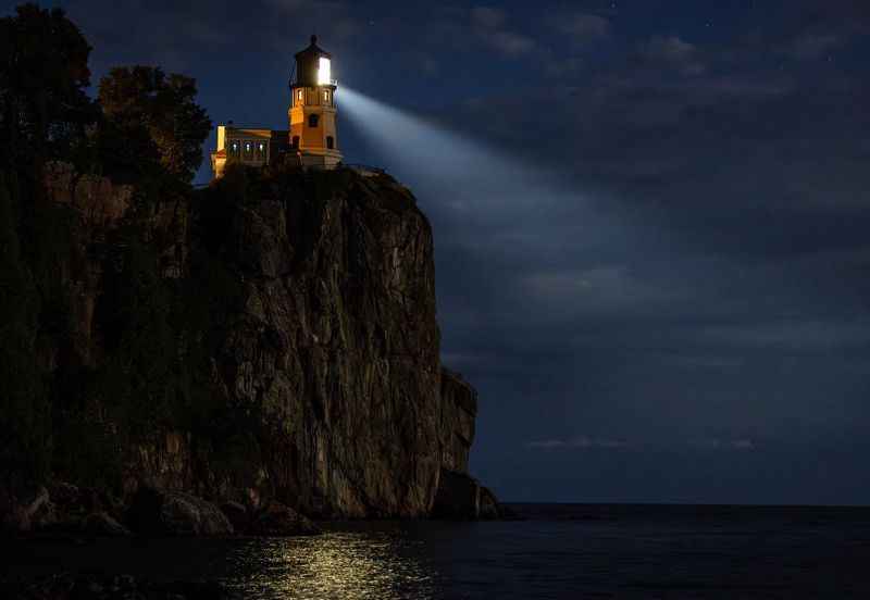 a lighthouse on a cliff at night