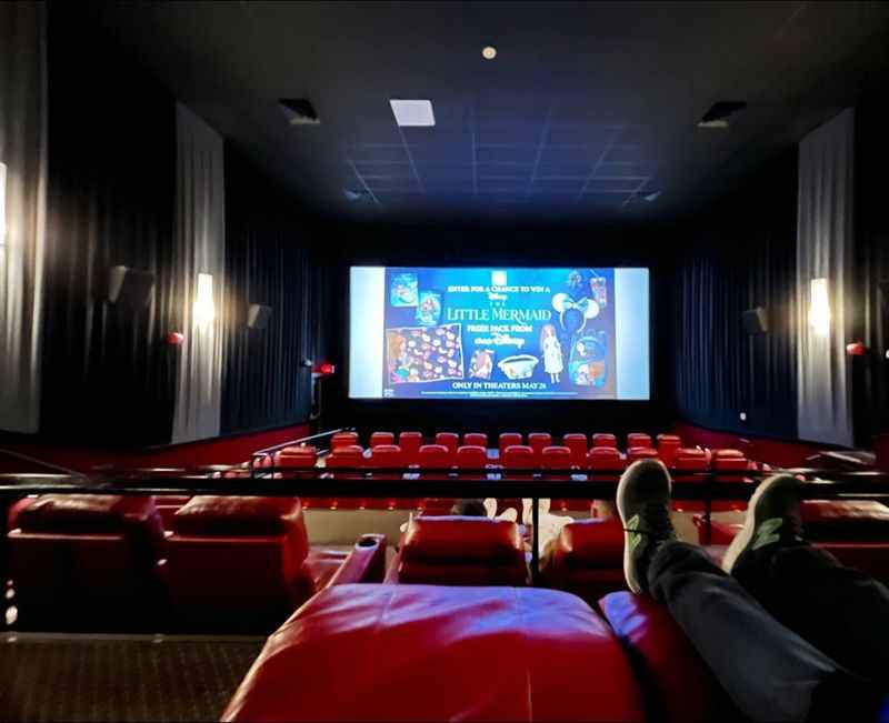 a person sitting in a red chair watching a movie