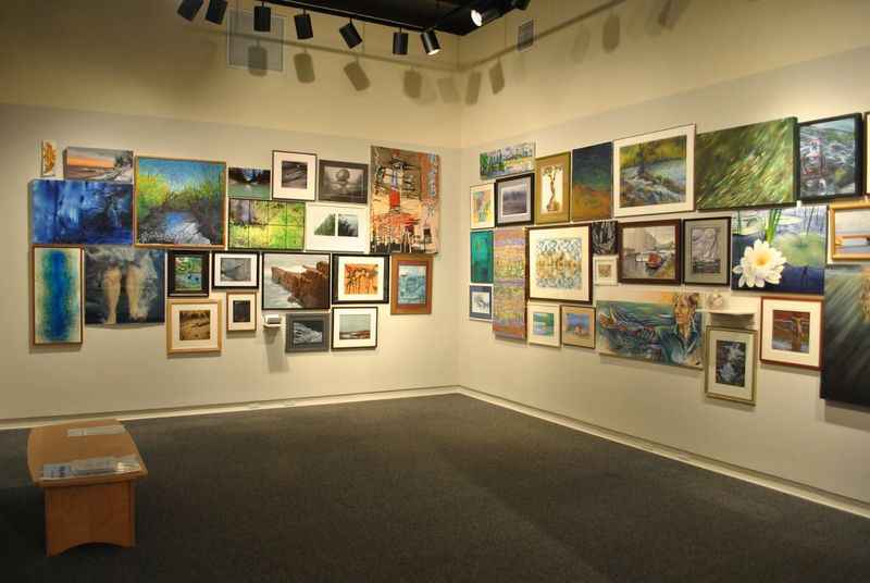 a wall of paintings in a room