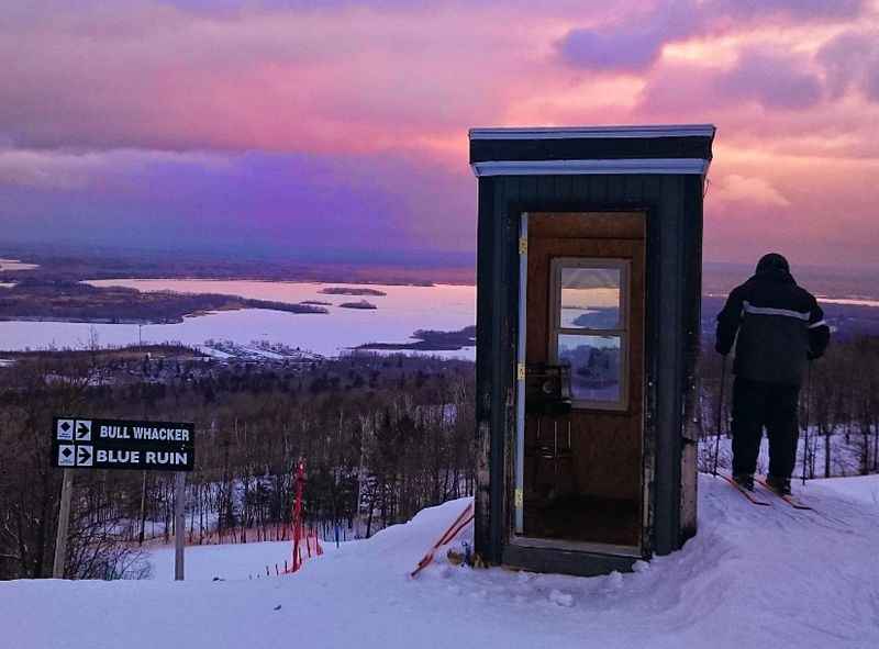 person standing on a snowy hill with a door