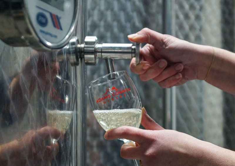 a person pouring a glass of wine into a glass