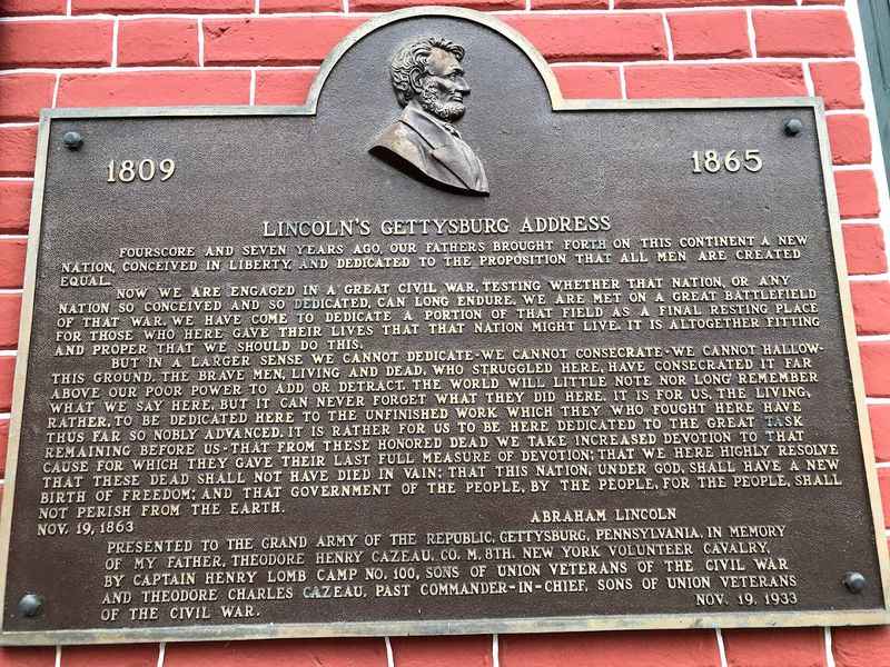 a plaque on the side of a brick building