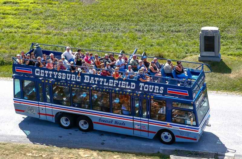 double decker tour bus with people on top of it