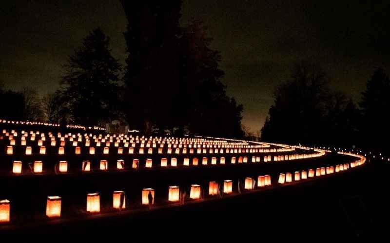 a row of lit candles in the dark